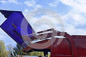 Garbage collector truck from municipal sanitation disposal service loads waste into a trash bin for recycling