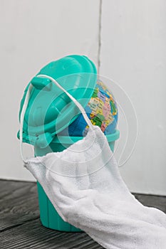 Garbage container with a globe. He is wearing a protective mask during a pandemic