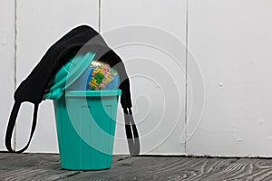 Garbage container with a globe. He is wearing a protective mask during a pandemic