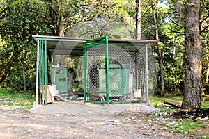 Garbage containers in fence cage / Orderly stowed garbage cans for separate garbage collection. photo