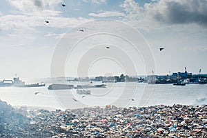 Garbage dump area landscape view full of smoke, litter, plastic bottles,rubbish and other trash at the Thilafushi tropical island