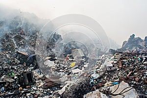 Garbage dump area view full of smoke, litter, plastic bottles,rubbish and other trash at the Thilafushi local island