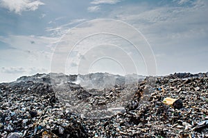 Garbage dump area view full of smoke, litter, plastic bottles, rubbish and trash at the Thilafushi local tropical island