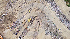Garbage Dump. Bulldozer At Garbage Landfill. Aerial Shot Of The Bulldozer Moving The Garbage And Trash
