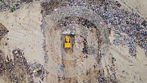 Garbage Dump. Bulldozer At Garbage Landfill. Aerial Shot Of The Bulldozer Moving The Garbage And Trash