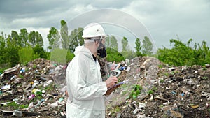 Garbage dump inspector records pollution level on city dump. Environmental pollution concept