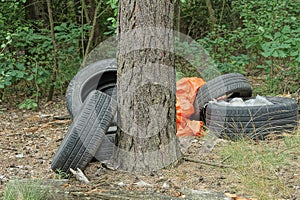 Garbage from a heap of black old car tires and red cellophane