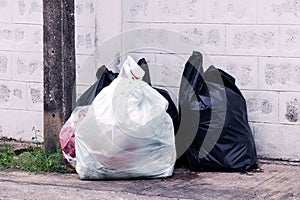 Garbage is pile lots dump, many garbage plastic bags black waste at walkway community village, pollution from trash plastic waste