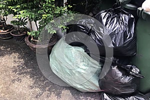 Garbage is pile lots dump, many garbage plastic bags black waste at walkway community village, pollution from trash plastic waste