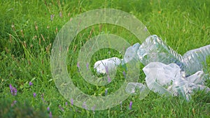 Garbage from plastic empty bottles in nature among the grass. Pollution of the environment.