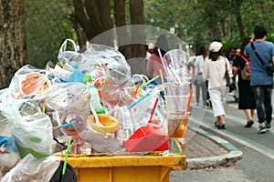 Garbage plastic Waste trash full of trash bin yellow and background people are walking on the sidewalk garden, Garbage bin, Trash