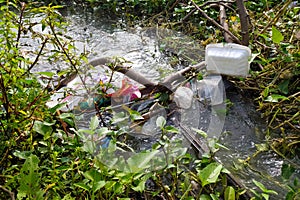 Garbage polluting waterways in ditch photo