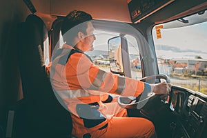 Garbage removal worker driving a dump truck