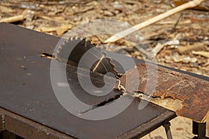 garbage at a sawmill. A circular saw is sawing a wooden piece. tree processing