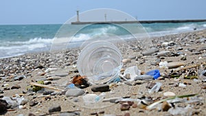 Garbage on the sea beach. A man-made garbage in the sea: plastic bottles, glasses and other plastic.