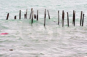 Garbage in the sea and the old rusty pier