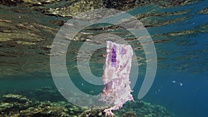 garbage in the sea. Plastic pollution of the sea. used, white plastic bag slowly drifting over the coral reef