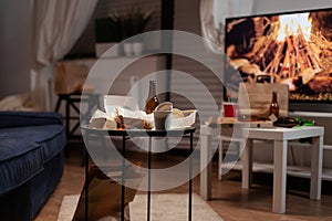 Garbage table with empty beer drink bottle and food rubbish placed in living room