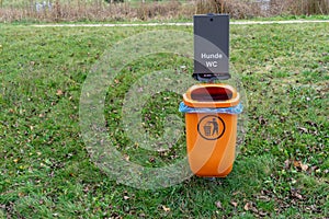 Garbage or trash bin in the park with the words `hunde WC` - dog toilet