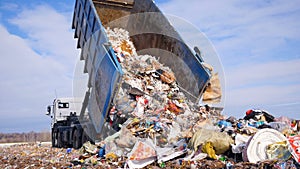 Garbage truck disposed trash on the landfill. Vehicle transporting garbage to waste.