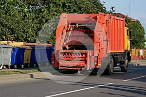 Garbage truck near garbage containers