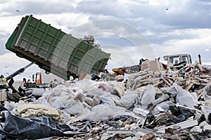 Garbage truck unloading garbage at dumping ground