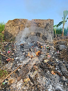 Garbage and useless items are burned on the edge of the rice fields