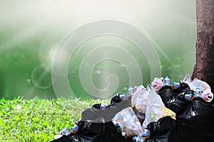 Garbage waste, heap of garbage plastic waste black and trash bag many at river park nature tree sunshine background