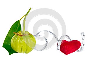 Garcinia cambogia fresh fruit with red heart and measuring tape, isolated on white. Fruit for diet and good health.