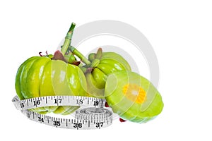 Garcinia cambogia fresh fruit with tapeline, isolated on white.