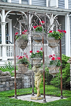 Garden Arbor with Red Begonia Hanging Baskets and Statue