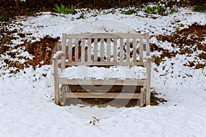 Garden bench covered in freshly fallen snow