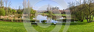 Garden bench overlooking the lake or pond of Parque da Devesa Urban Park in Vila Nova de Famalicao photo