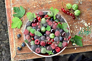 Garden berries in a bowl on wooden table