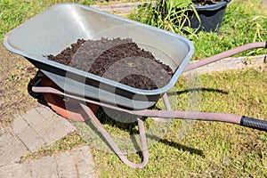 Garden cart with peat on the lawn