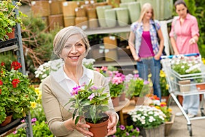 Garden centre senior lady hold potted flower