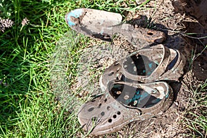 Garden clogs and shovel standing on the mud
