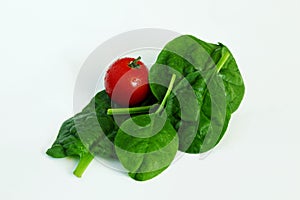 Garden fresh green leafy vegetable spinach leaf also known in india as palak bhaji with tomato isolated on white background,copy s