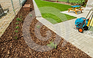 Garden with fresh new lawn and bark mulch area to reduce weed growth