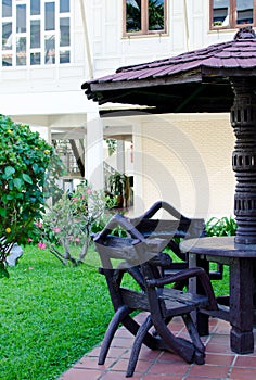 Garden furniture. chairs and table under wooden umbrella at garden