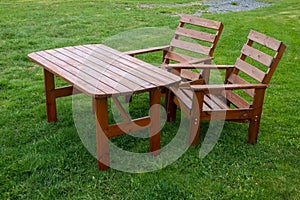 Garden furniture - an outdoor wooden table and chairs on the grass
