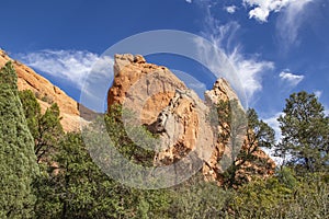 Garden of the Gods in Colorado Springs - huge red rock bluffs jut upwards against dramatic blue sky with whispy clouds