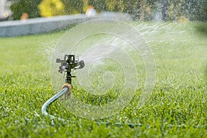 Garden irrigation system watering lawn. watering the lawn in the hot summer. Lawn sprinkler spaying water over green grass. Irriga