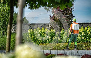 Garden Keeper Spaying Chemicals Used to Control Insects photo