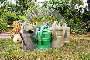 Garden with many old watering cans in a dry summer