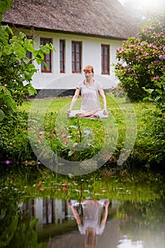 Garden meditations. a woman sitting in the lotus position in her backyard.