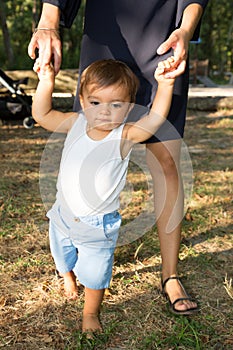 Garden mother and son holding hand in hand learn to walk