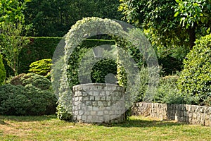 Garden with Old Water Well With Pulley and Bucket