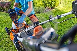 Garden Owner Replacing Batteries Inside His Grass Mower