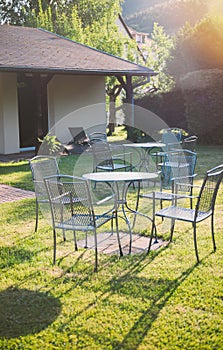 Garden party summer day atmosphere with empty table and chairs